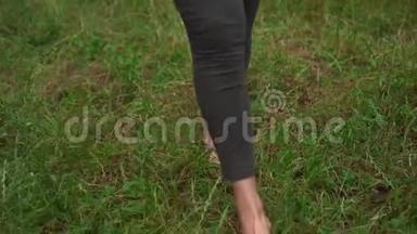 做瑜伽的孕妇。 一个女孩手里拿着一块地毯走路，然后把地毯扔到草地上开始练习。